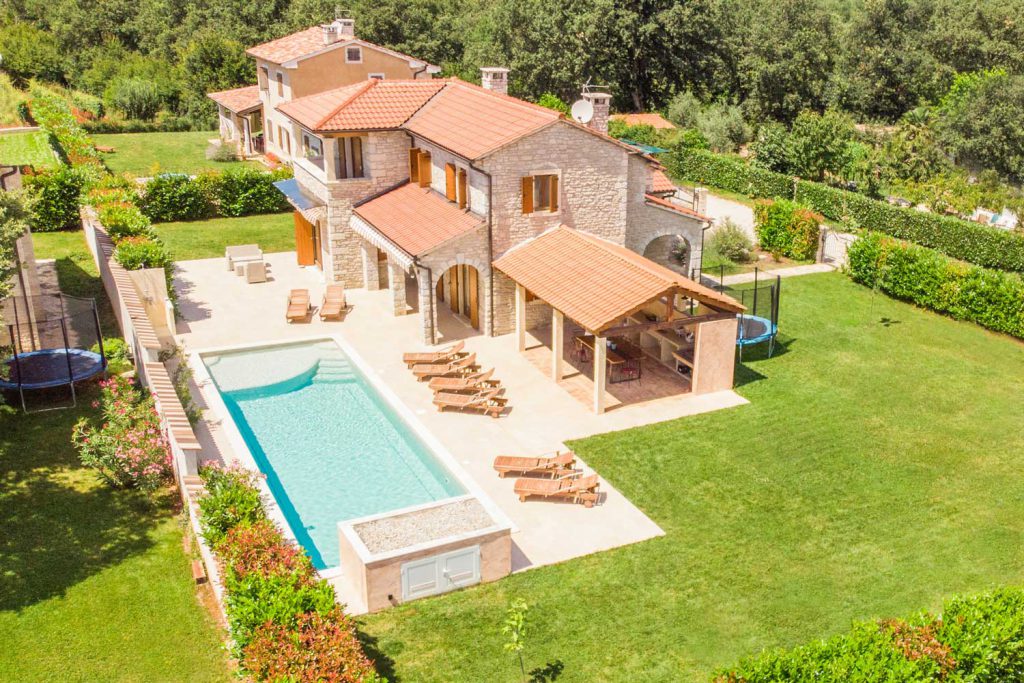 Auf dem Grundstück der Villa Begonia der Villas Istria bringt der große Swimmingpool der ganzen Familie Spaß. Ein großes Trampolin und die rustikale Außenküche sorgen bei Kindern und Eltern für ein entspanntes Urlaubsfeeling.