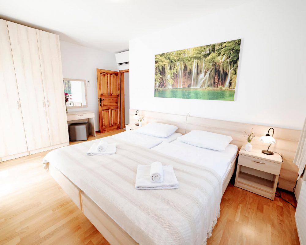 Das gemütliche Schlafzimmer, der Villa Alma, hat ein komfortables Doppelbett mit zwei Nachttischen, zwei Tischlampen und mehr..