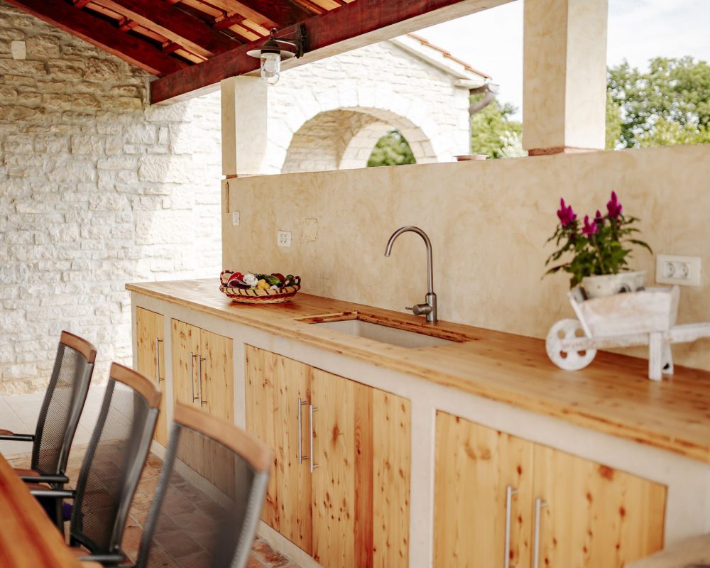 Im Außenbereich der Villa Begonia befindet sich eine überdachte, rustikale Außenküche. Hier kann gekocht und gegrillt werden.