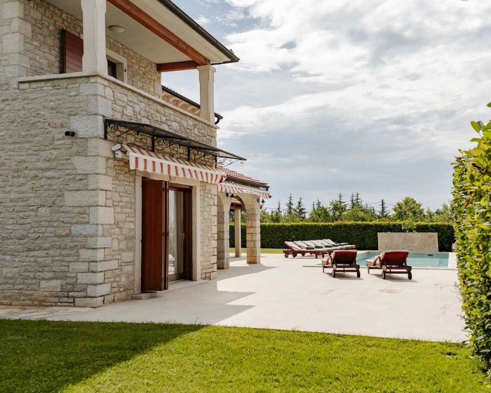 Im Außenbereich der Villa befindet sich eine große Terrasse mit bequemen Sonnenliegen.