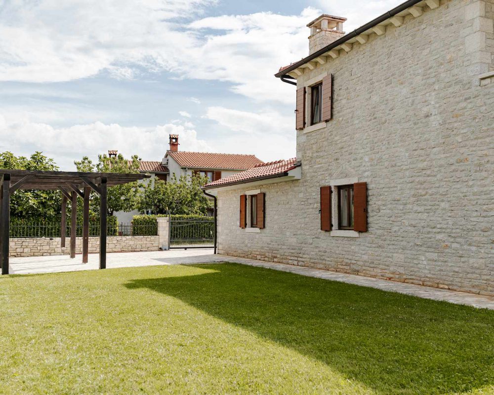 Im Außenbereich der Villa befindet sich ein überdachtes Carport.