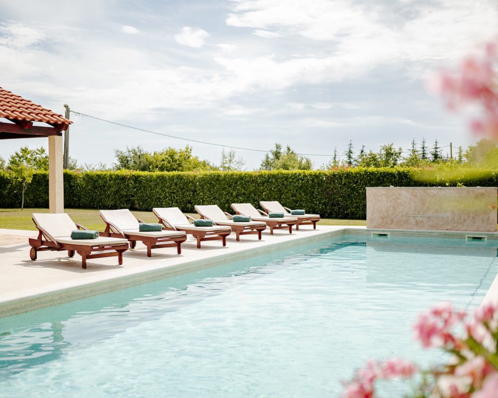 Der 50m² große Pool hat einen flachen Bereich, perfekt für kleine Kinder oder zum sitzen. Ein paar Treppenstufen führen in den tieferen Bereich mit Wasserfall.