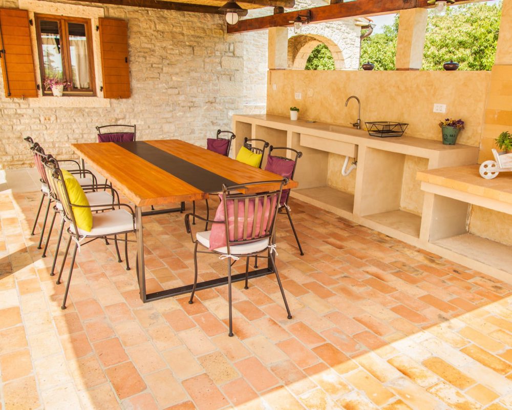 Im Außenbereich der Villa befindet sich eine überdachte, rustikale Außenküche. Hier kann gekocht und gegrillt werden.